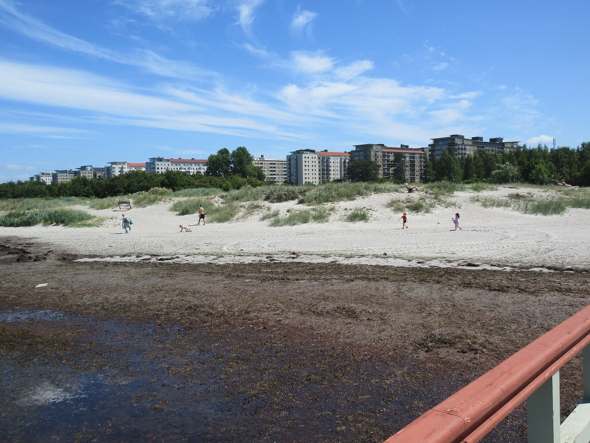 Ribersborgsstranden i Malmö med sand, lavt vand og byen i baggrunden