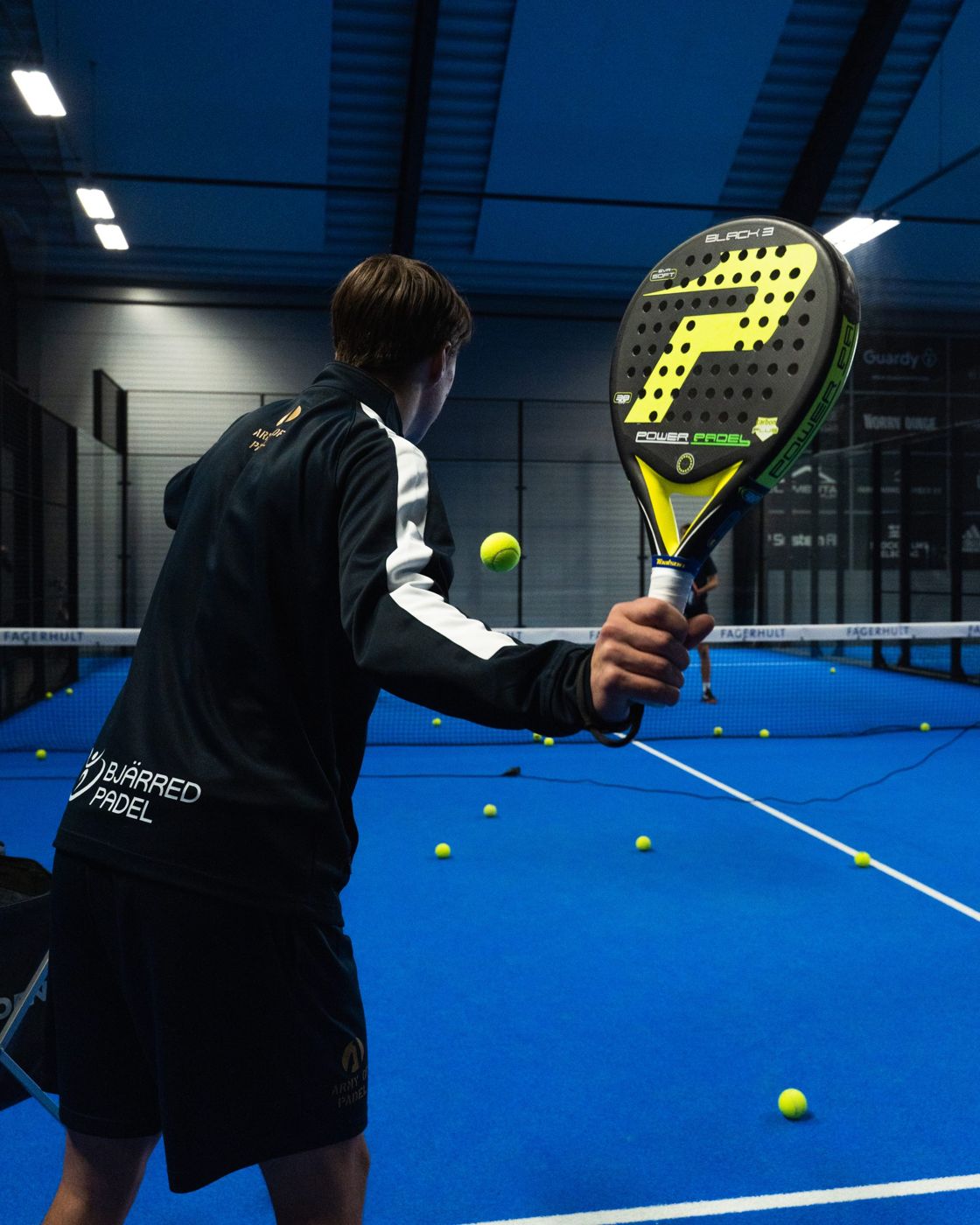 A player at Bjärred Padel's indoor blue courts
